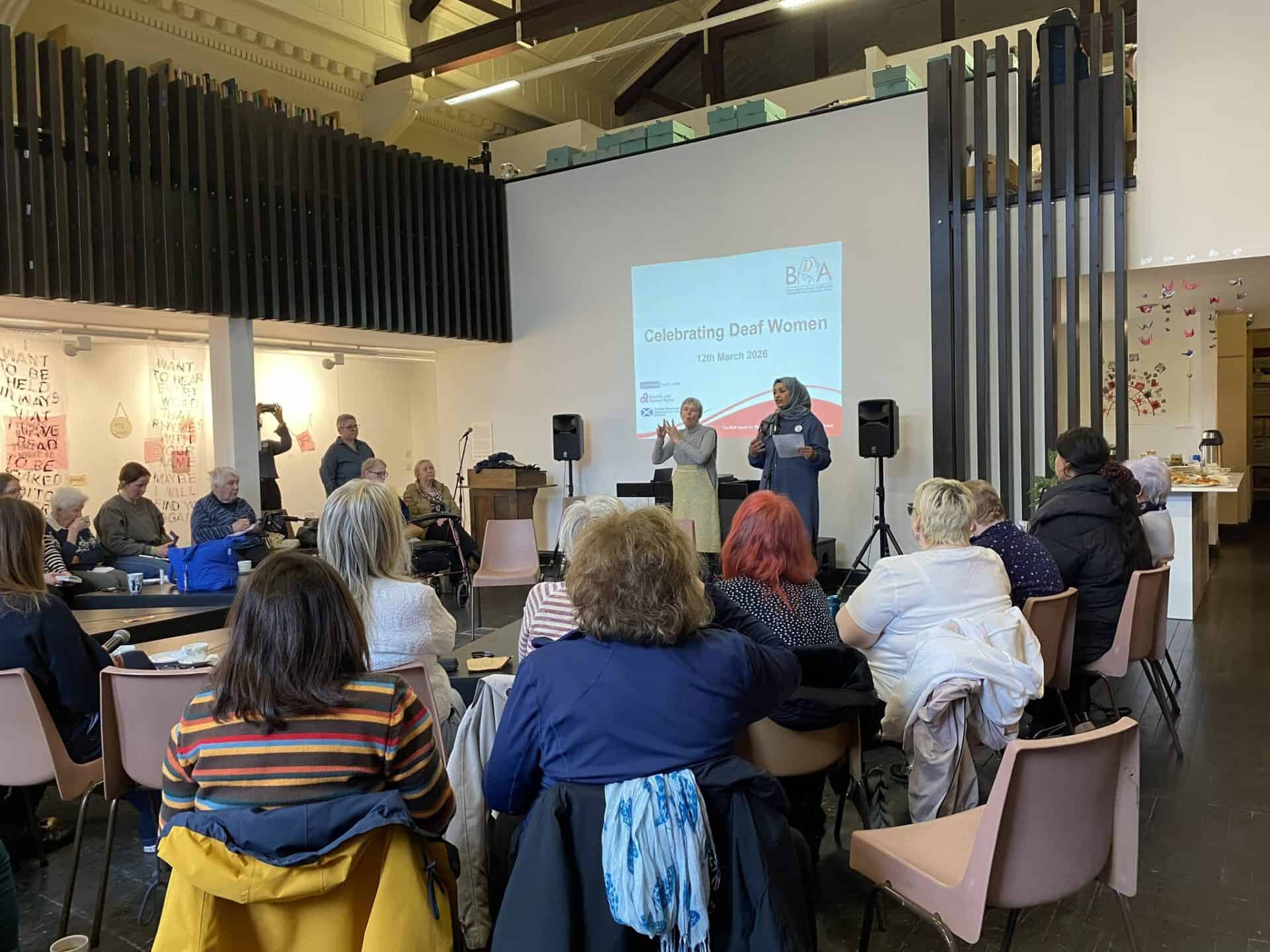 Deaf women event celebrating BSL (Scotland) Act 2015 with sign language interpreters.