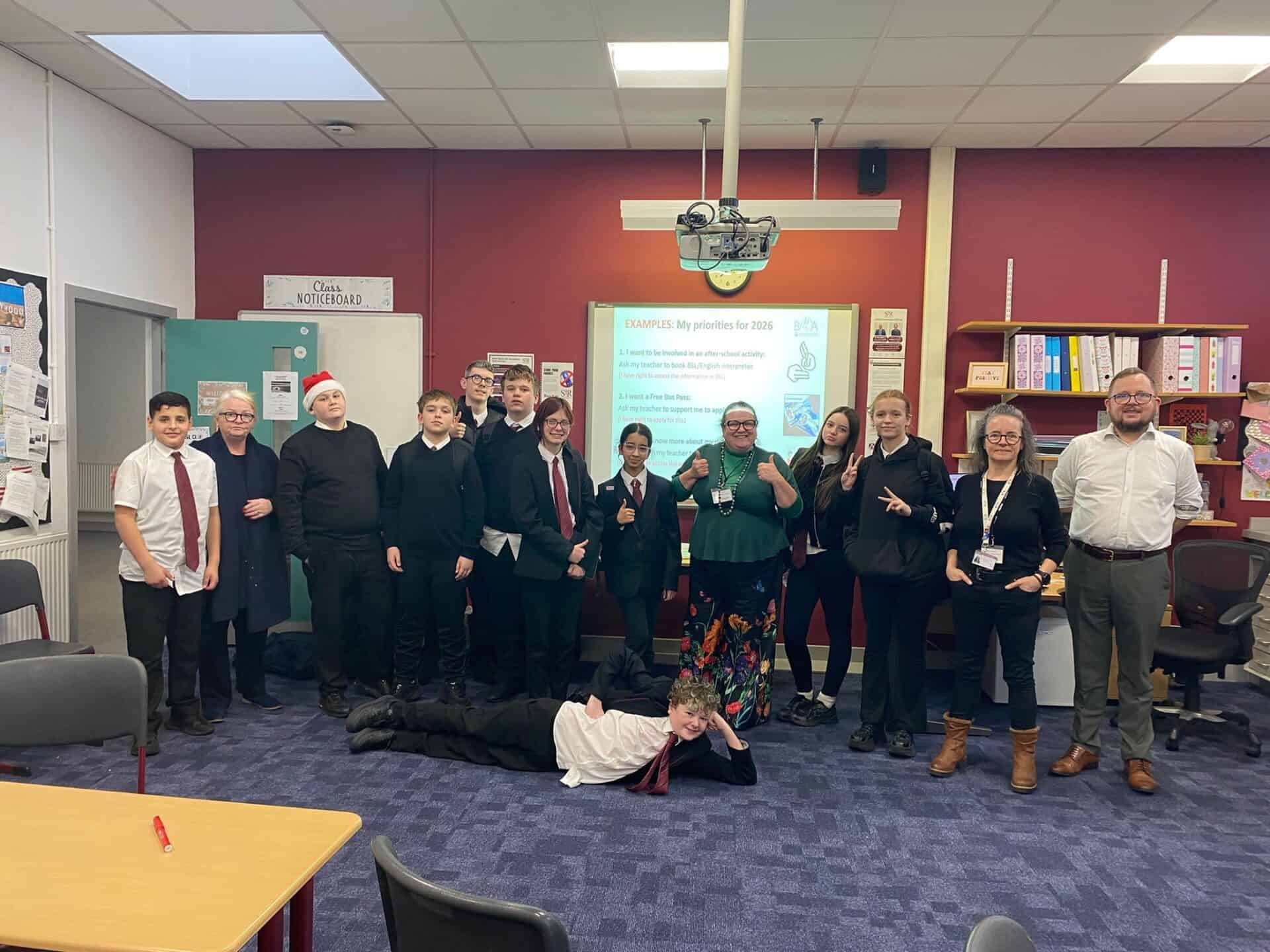 Group of people in a classroom with a presentation on BSL Scotland Act 2015.