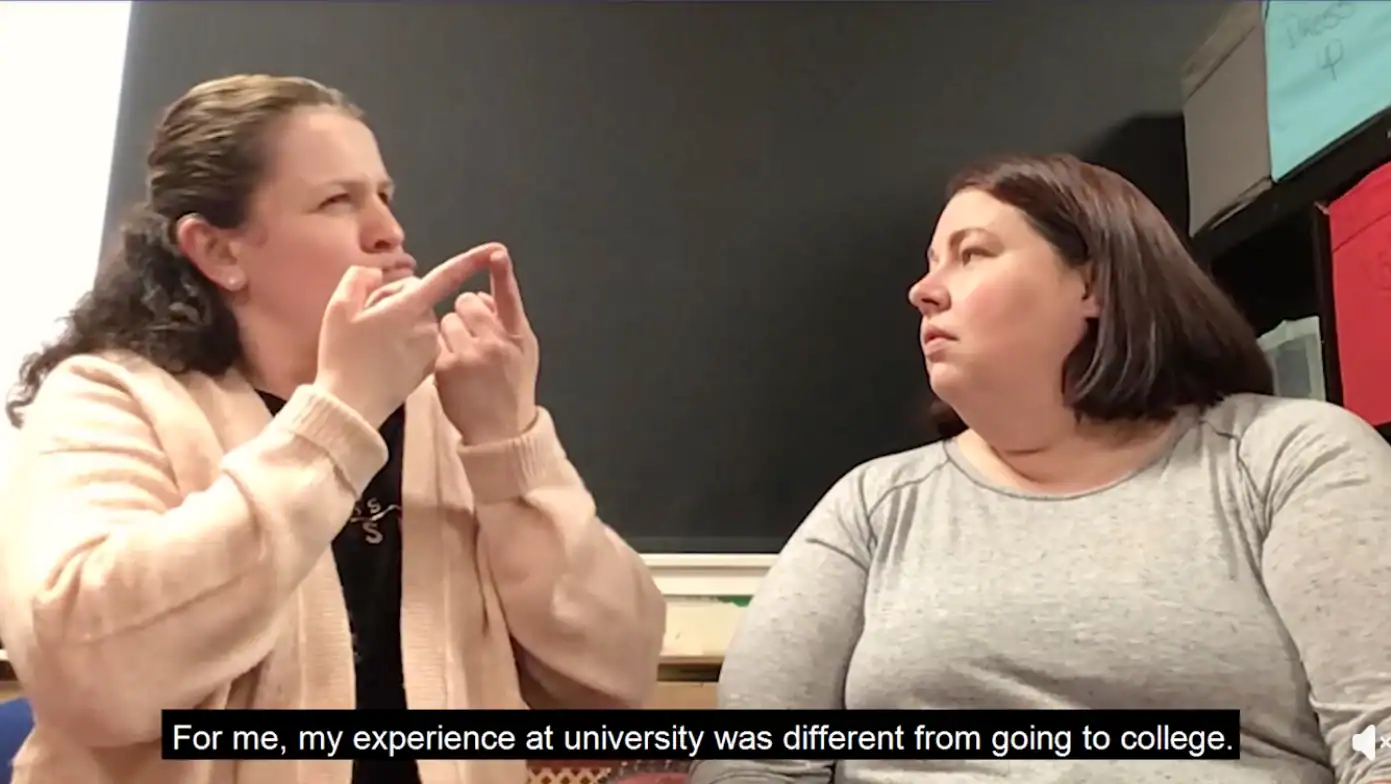 Deaf women communicating using sign language in a university setting.