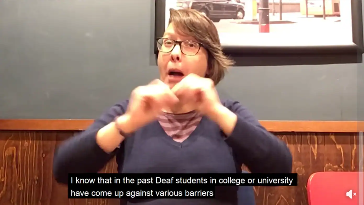Deaf woman using sign language discussing barriers in education.