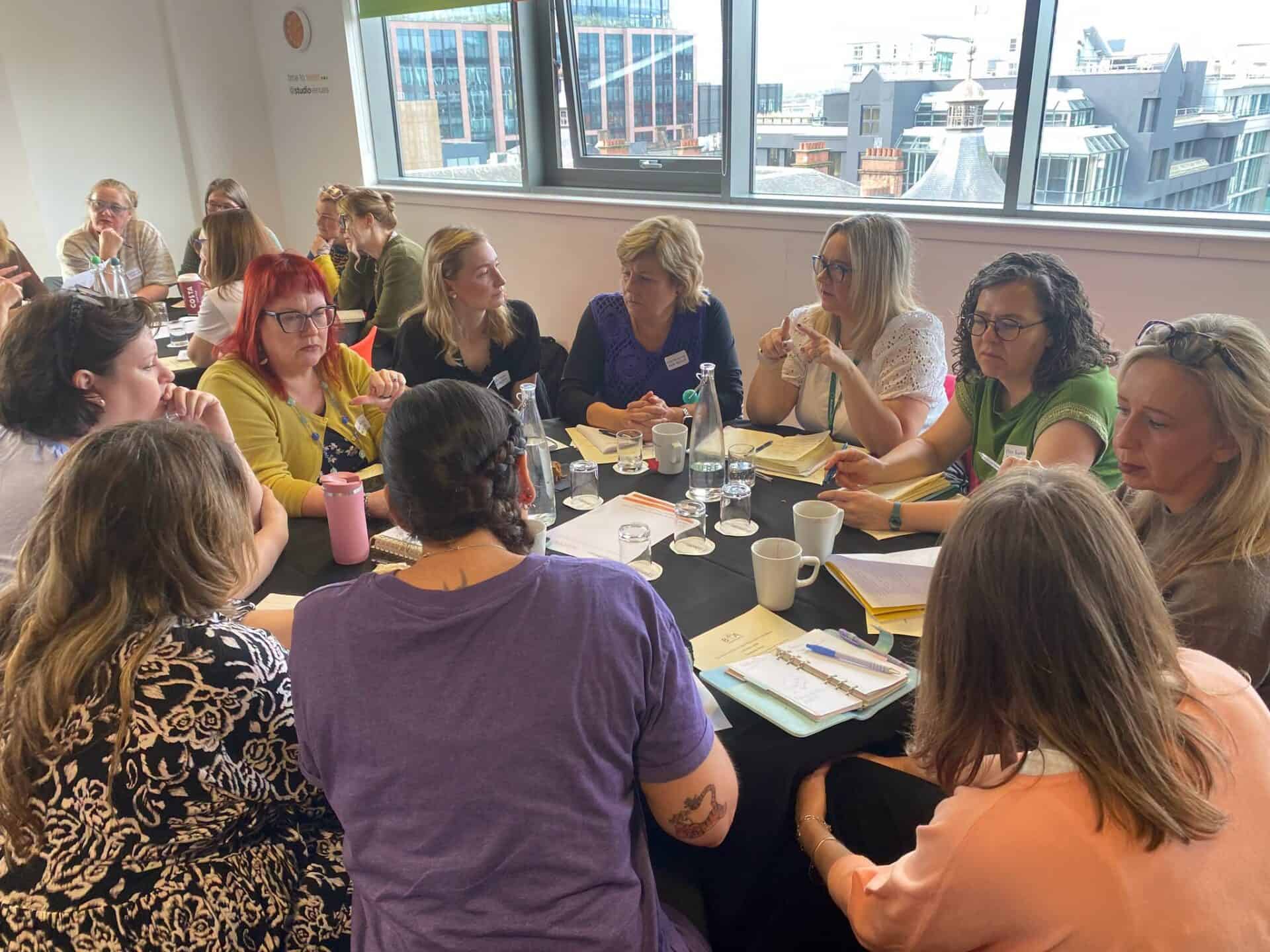 Group of women discussing BSL (Scotland) Act 2015 in a meeting room.
