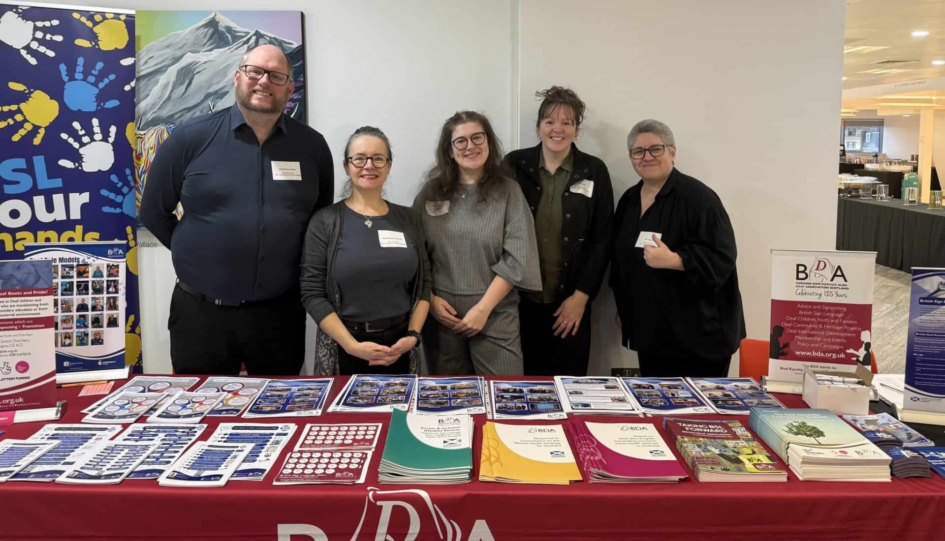 Group of five people at BSL Act 2015 information stand in Scotland.